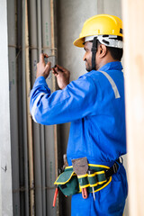 Plumber busy taking photos of construction site for work reference for insurance claim - concept of measuring digitally using smartphone technology.