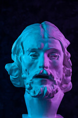 Colorful gypsum copy of ancient statue of John the Baptist head for artists on a dark textured...
