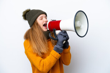 Teenager Russian girl wearing winter jacket isolated on white background shouting through a megaphone