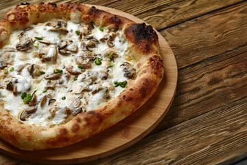 Appetizing pizza with mushrooms on a wooden tray
