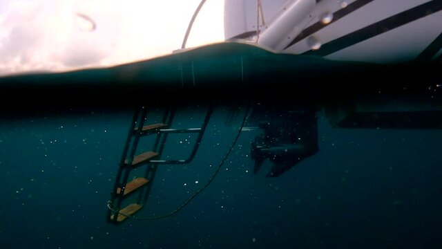Underwater film in 4k of outboard engine and propeller of large speed boat off the coast of Koh Phangan island in Thailand