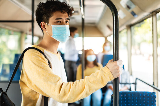 Portrait of asian man in facemask standing in bus