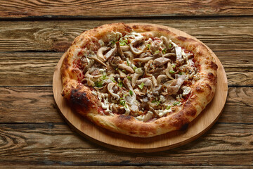 Delicious homemade pizza with mozzarella, mushrooms, beef and chicken. Dark background, selective focus.