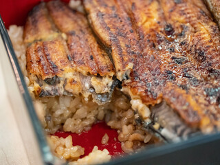 食べかけのうな重。関東風のタレがかかった鰻の蒲焼とごはん。