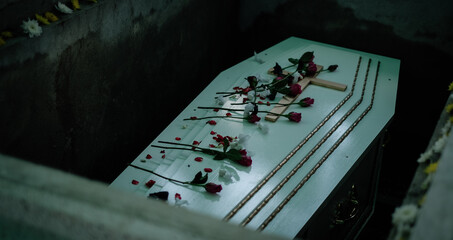 White wooden coffin with Cross and rose flowers