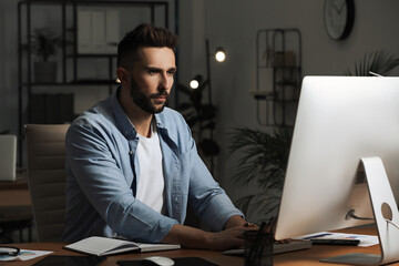 Man working on computer at table in office