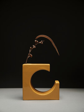 Ramo di eucalipto secco in vaso di modernariato giallo, ambientazione interna, fotografia da studio