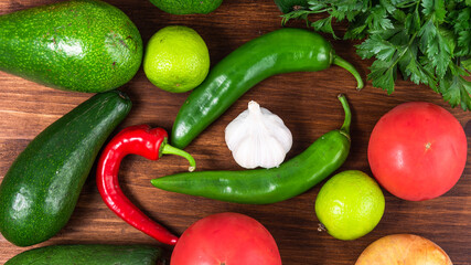 Ingredients for cooking a traditional Mexican dish guacamole - avoado, tomatoes, garlic, cilantro,...