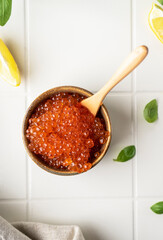 Natural red caviar from trout and salmon. A pure product, a delicacy. On a white background in a beautiful presentation