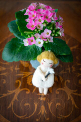 Fairy doll with magic wand with star to fulfil wishes on wooden table with flowers