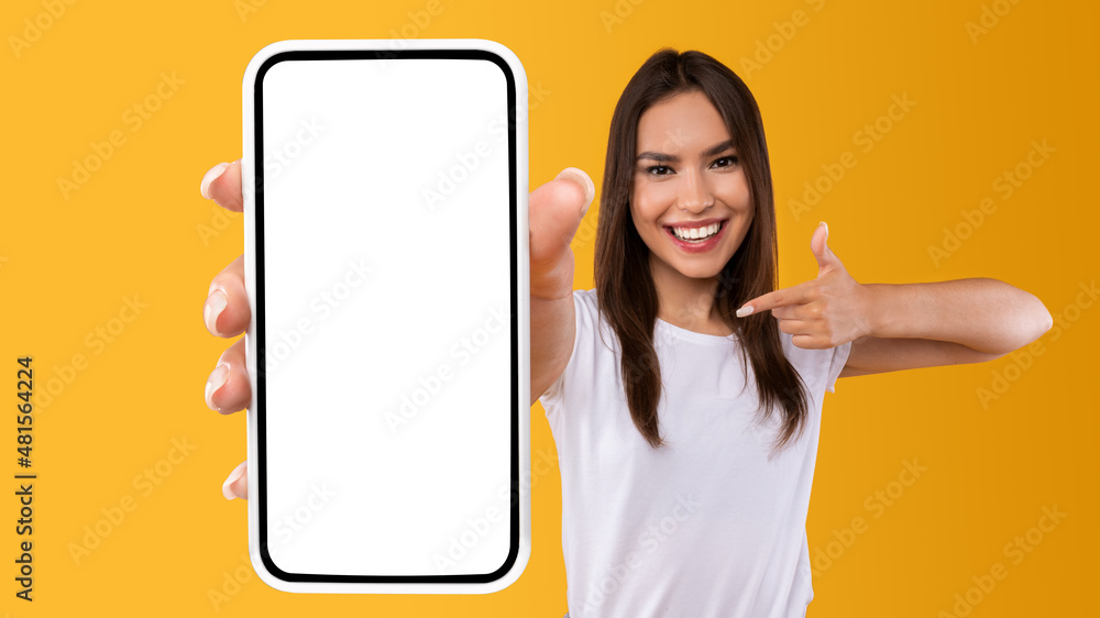 Poster woman showing white empty smartphone screen and pointing