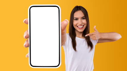 Woman showing white empty smartphone screen and pointing