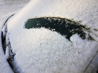 Frost on the windshield, snow on the car. Snow storm in the city. Winter snowfall. Cleaning the car from snow.