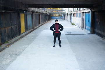 Sporty Muslim female standing determined in an alleyway