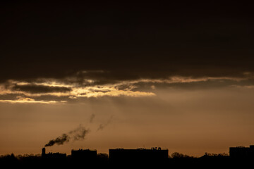 Fototapeta premium lever de soleil sur la ville, fumée de cheminée
