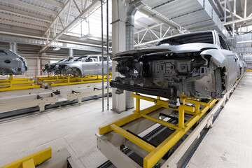 Car bodies are on assembly line. Factory for production of cars. Modern automotive industry