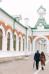 couple in fall clothes walking to the train station. The concept of travel