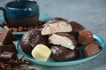 Zefir (zephyr),coffee cup, beans, chocolate on kitchen table Assortment of dark, white and milk chocolate sweets.