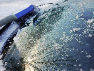 Frost on the windshield, snow on the car. Snow storm in the city. Winter snowfall. Cleaning the car from snow.