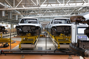 Photo of automobile production line. Modern car assembly plant. Auto industry. Interior of a high-tech factory, modern production