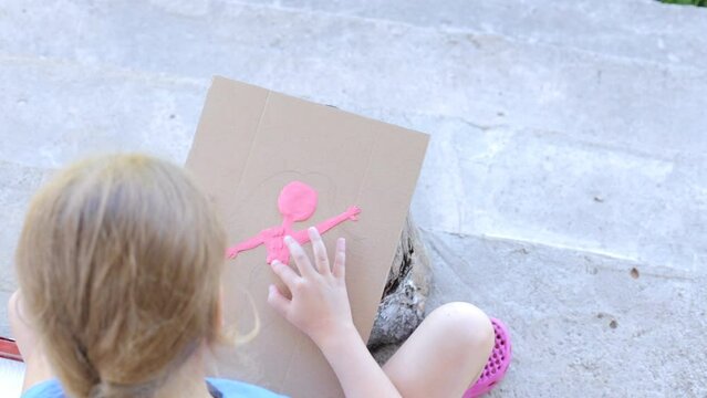 The child sculpts a picture from plasticine. Top view of a child sculpting with plasticine