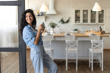 Beautiful young lady relaxing with cup of coffee at home, copy space
