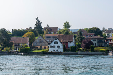 Fototapeta na wymiar Rhine river and the coastline with trees and houses in Stone at the Rhein town on sunny summer day