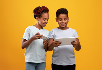 Black girl with smartphone and boy with digital tablet