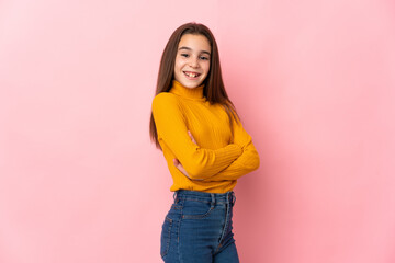 Little girl isolated on pink background with arms crossed and looking forward