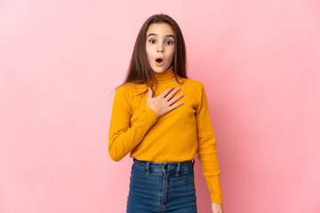 Little girl isolated on pink background surprised and shocked while looking right