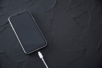 Mobile smart phone on wireless charging device on white background. Icon battery and charging...