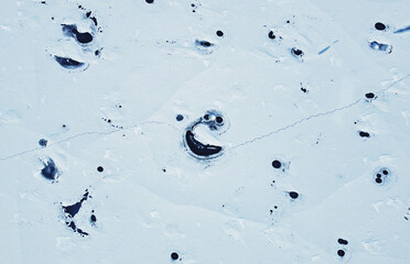 Aerial view of the snowy texture of a frozen lake in winter. North Pole and ice