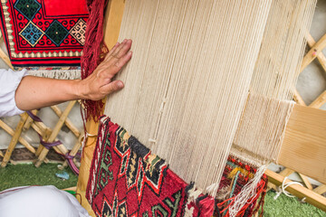 Making a carpet by hand in a Kazakh yurt