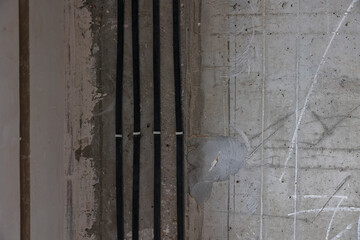 Wires in black insulation between the floors of an apartment building. Power rail