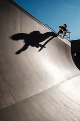 Foto auf Leinwand Young skater dropping on mega ramp with big shadow © howardponneso