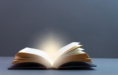 Mystery open book with shining light . Fantasy book with magic light  and stars on a table with...