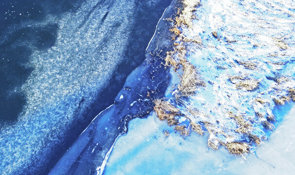 Aerial view of the texture of frozen wildlife in winter. Photo of ice and snowy river from above