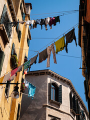 clothes hang on washing line between houses window with a shutter