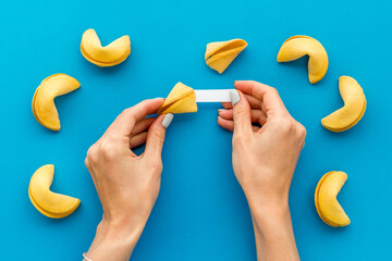 Female hands open Chinese fortune cookie. Chinese New Year background