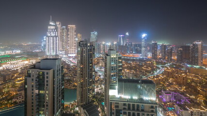 Fototapeta premium Aerial panoramic view of a big futuristic city all night timelapse. Business bay and Downtown