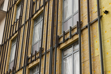 Aluminum rails for fastening a curtain wall system made of tiles on a wall with windows. Insulation...
