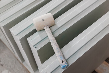 Weatherproof gypsum blocks at the construction site. A wooden mallet lies on top. building non-load bearing partition wall of gypsum blocks. massive lightweight building material