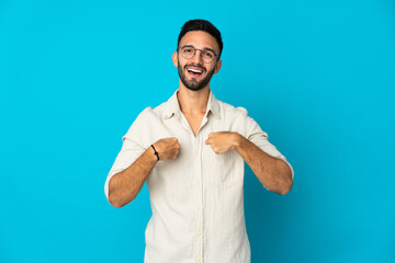 Young caucasian man isolated on blue background with surprise facial expression