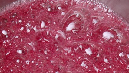 Close-up of the preparation of pink caramel. Making lollipops