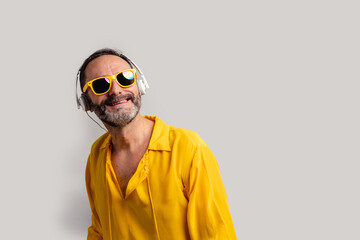 Mature man on yellow shirt on grey background