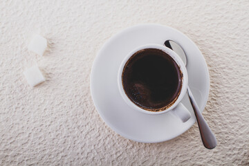 Cup with black coffee and two pieces of sugar, top view minimalistic