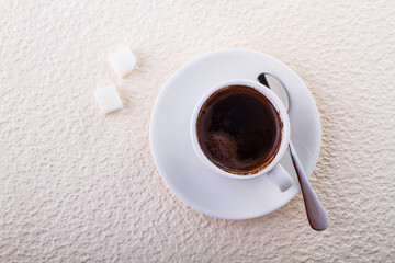 Cup with black coffee and two pieces of sugar, top view minimalistic