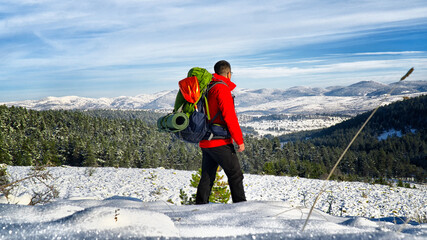 Backpacker hiking on snow covered mountain. Winter active time