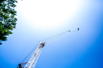Bungee jumping man with tower and sky