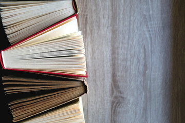 Bunch of vintage hardcover books on wooden background. Top view.